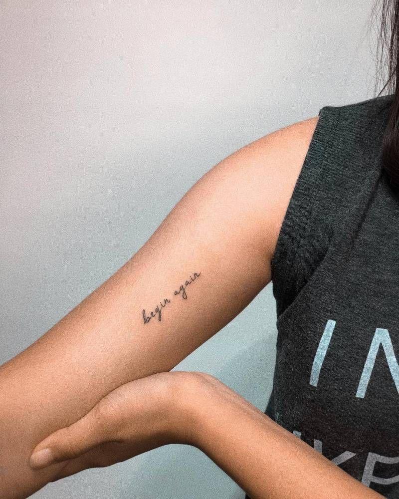 Tattoo chữ Begin Again (bắt đầu đầu lại) ở bắp tay